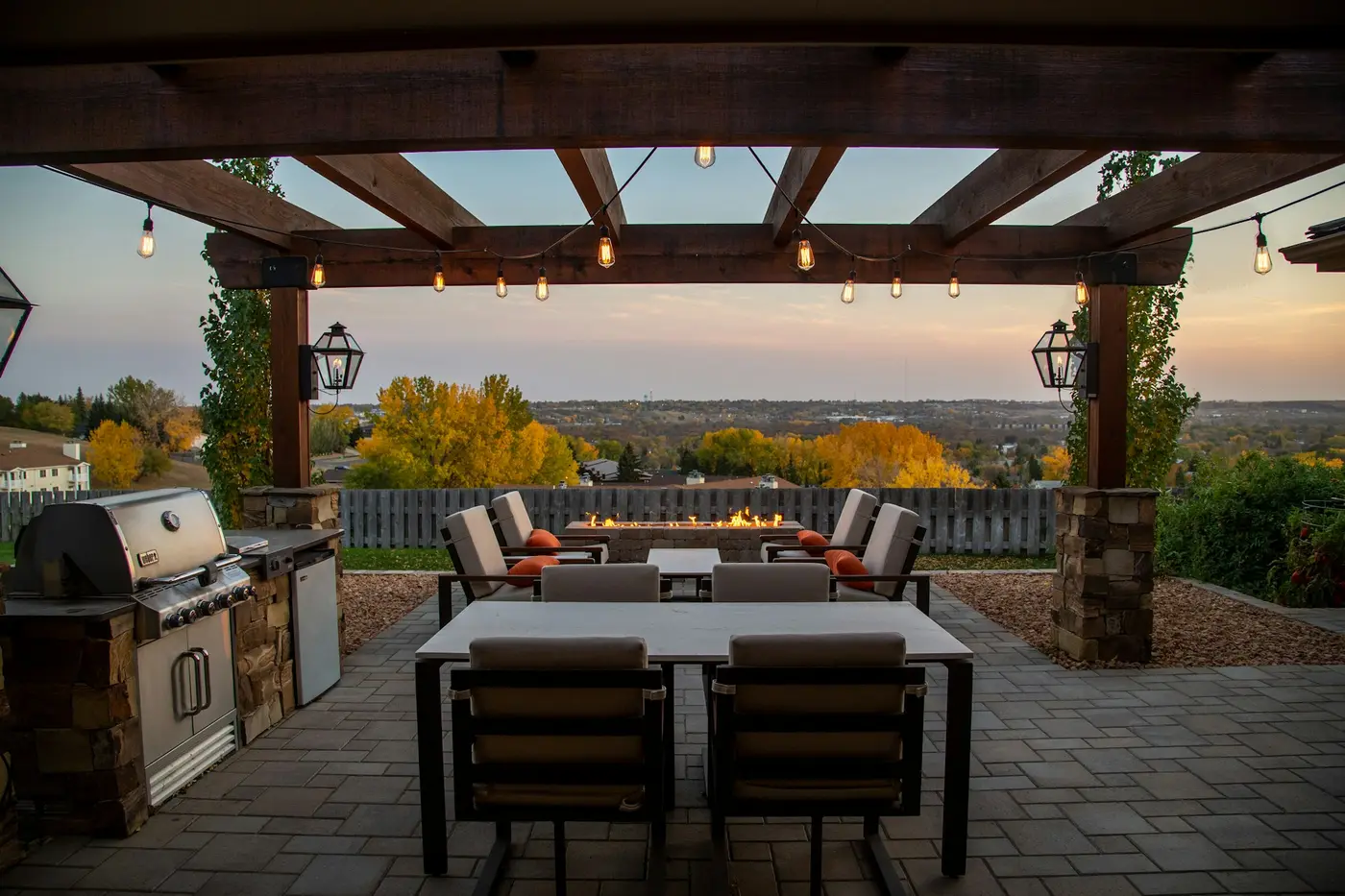 Covered patio with an outdoor kitchen at dusk